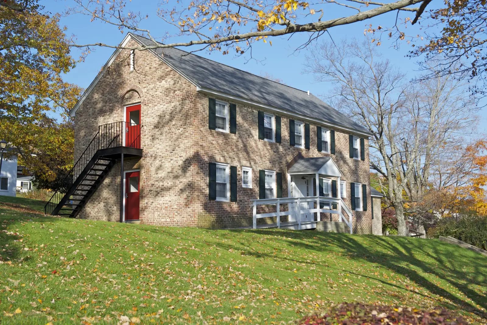 Sloped lawn with stone edging in front of a New England home